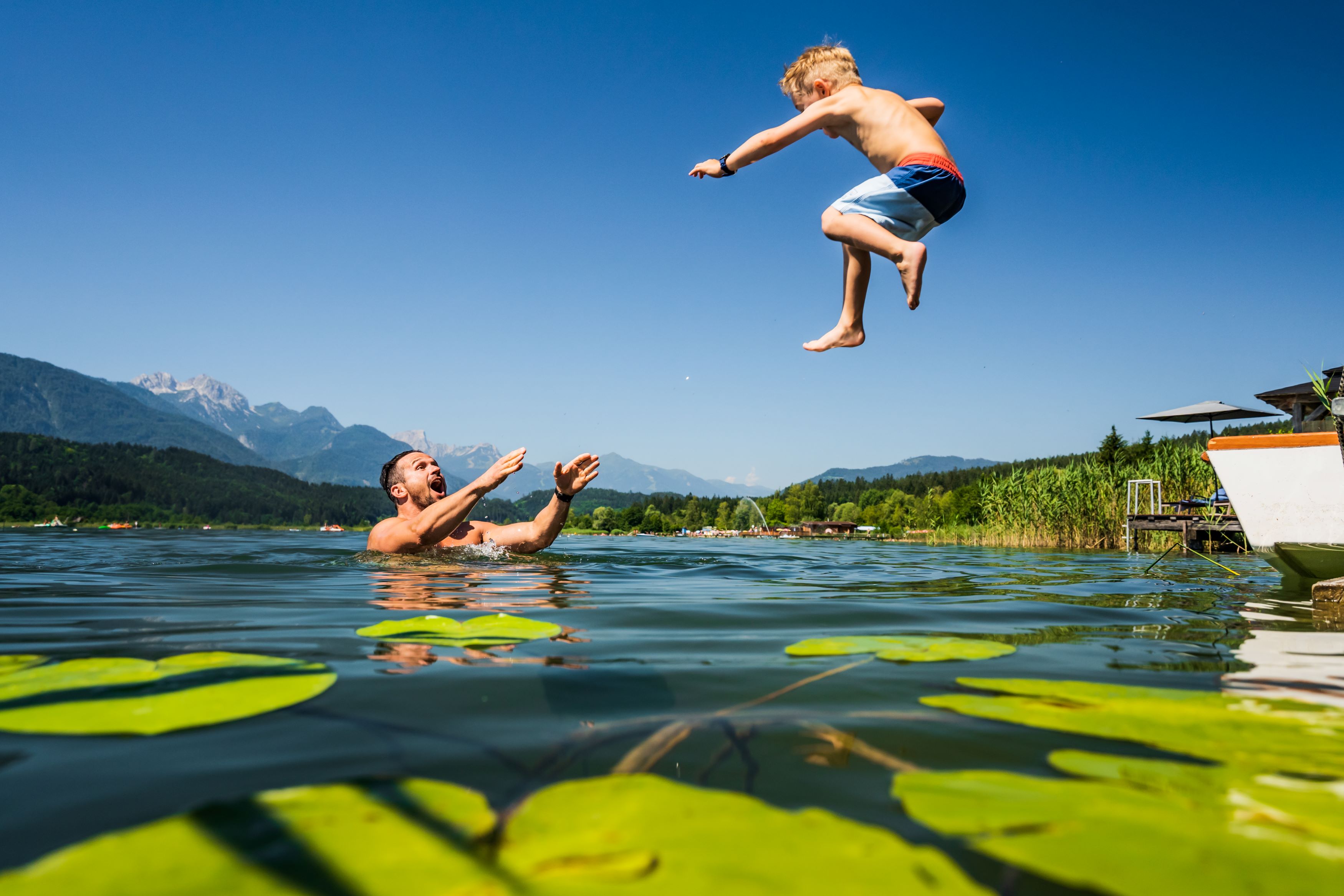 Ein Mann und ein Kind springen ins Wasser.
