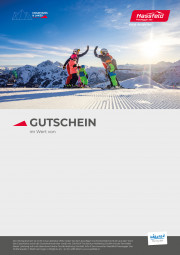 eine Familie mit zwei Kindern genießt die Sonne auf der Piste